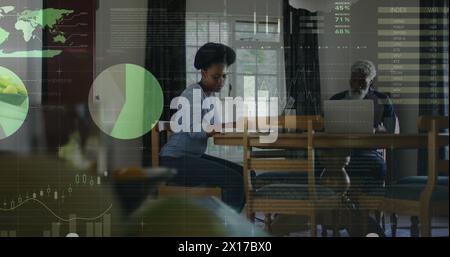 Image du traitement des données financières sur un père afro-américain et une fille adulte utilisant des ordinateurs portables Banque D'Images