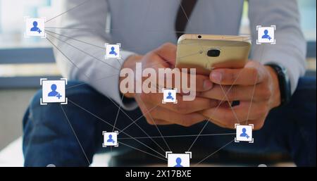 Image du réseau d'icônes de profil sur la section médiane de l'homme caucasien à l'aide d'un smartphone au bureau Banque D'Images