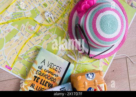 La carte, la valise, le chapeau rose, les lunettes et les écouteurs pour le téléphone sont nécessaires pour un voyage d'été en Espagne. Banque D'Images