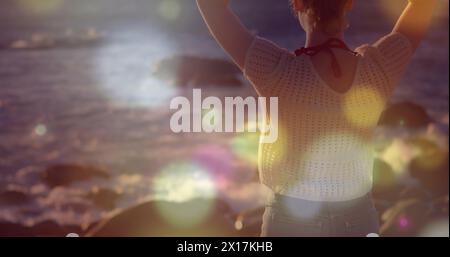 Image de taches lumineuses sur une femme caucasienne à la plage Banque D'Images