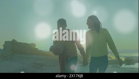 Image de taches lumineuses sur un couple caucasien à la plage Banque D'Images
