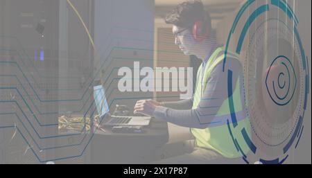 Scanner rond de rétine d'image contre ingénieur masculin asiatique utilisant un ordinateur portable dans la salle de serveur informatique Banque D'Images