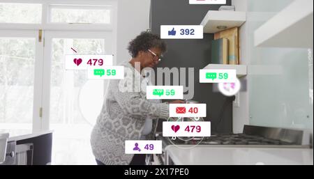 Image de texte et d'icônes de médias sociaux sur une femme afro-américaine senior à la maison Banque D'Images