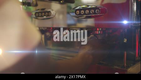 Image des taches de lumière sur l'homme biracial à l'aide d'une machine à café Banque D'Images