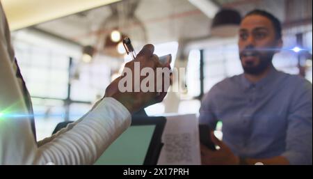 Image de taches lumineuses sur un homme biracial commandant dans un café Banque D'Images