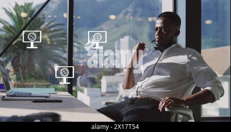 Image du réseau d'icônes d'écran avec globes sur homme d'affaires afro-américain dans le bureau Banque D'Images