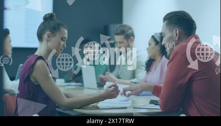 Image de globe avec des icônes de flèches sur divers gens d'affaires à la réunion dans le bureau Banque D'Images