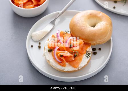 Bagel avec saumon fumé, fromage à la crème, câpres et oignon rouge pour le petit déjeuner Banque D'Images