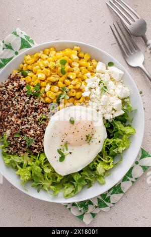 Bol de petit déjeuner quinoa avec laitue, oeuf frit, fromage feta et maïs Banque D'Images