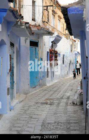 Chefchaouen, Une personne se promène dans une rue avec des maisons bleues traditionnelles, Chefchaouen, Maroc Banque D'Images