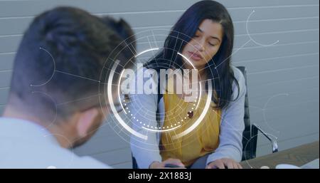 Image de scanner rond contre divers hommes et femmes discutant au-dessus d'un document au bureau Banque D'Images