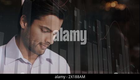 Image de graphiques financiers sur heureux homme d'affaires caucasien au bureau Banque D'Images