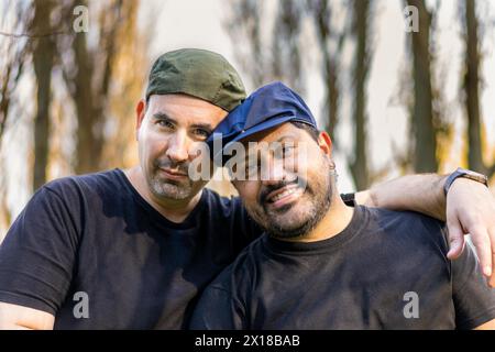 Deux hommes se serrent dans leurs bras tout en regardant la caméra Banque D'Images