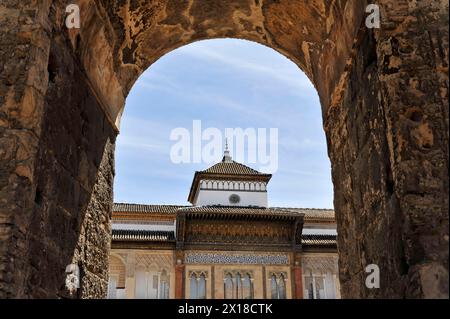 Séville, Palais Royal Real Alcazar, site du patrimoine mondial de l'UNESCO, à Séville, Séville, vue à travers une arche de la façade à motifs d'un bâtiment Banque D'Images