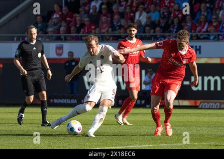 Match de football, capitaine Patrick MAINKA 1.FC Heidenheim droit dans un duel avec le tir Harry KANE Bayern Munich, arbitre Robert Schroeder et Eren Banque D'Images