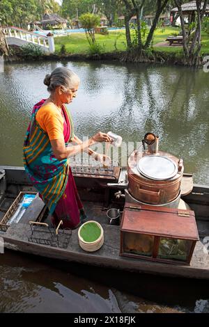 Tealady, 83 ans, fait du thé indien sur son bateau, Backwaters, Kumarakom, Kerala, Inde Banque D'Images