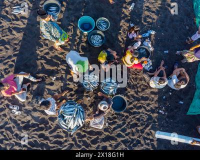 Les pêcheurs déchargent leurs prises de leur bateau en porte-à-faux le matin. Amed, Karangasem, Bali, Indonésie Banque D'Images