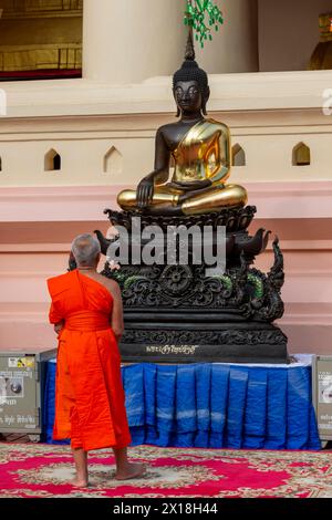 Moine devant une statue de Bouddha, Bhumispara-mudra, Bouddha Gautama au moment des lumières, Wat ONG teu, Vientiane, Laos Banque D'Images