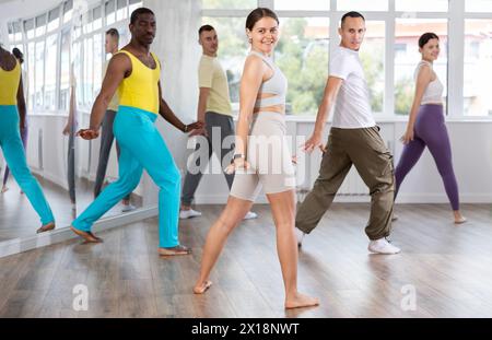 Jeune instructrice de fitness menant une classe de Zumba optimiste Banque D'Images