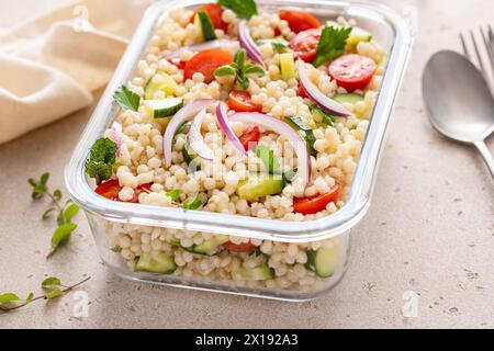 Salade de couscous perle avec des légumes frais et des herbes dans un récipient de préparation de repas, déjeuner sain ou idée de plat d'accompagnement Banque D'Images