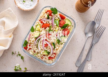 Salade de couscous perle avec des légumes frais et des herbes dans un récipient de préparation de repas, déjeuner sain ou idée de plat d'accompagnement Banque D'Images