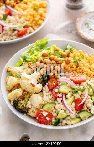 Bol repas végétalien avec légumes rôtis, laitue fraîche, lentilles cuites, salade de couscous et pois chiches grillés croustillants Banque D'Images