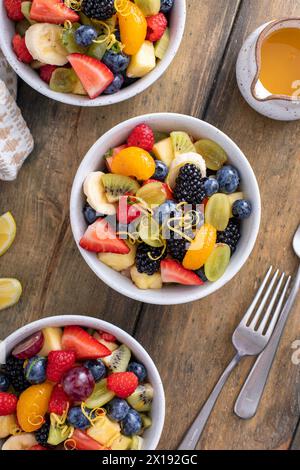 Salade de fruits avec baies fraîches, bananes et pommes dans de petits bols avec vinaigrette à la menthe et aux agrumes Banque D'Images