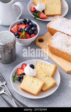 Gâteau traditionnel à la livre de vanille coupé en tranches et servi avec de la crème fouettée et des baies fraîches Banque D'Images