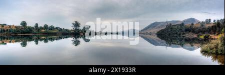 Reflets parfaits dans un lac par une journée nuageuse. Banque D'Images