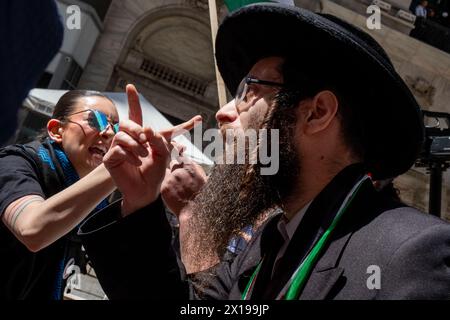 New York, États-Unis. 15 avril 2024. Membre de la Naturei Karta, une secte anti-sioniste juive ultra orthodoxe vue se disputer pendant le rassemblement. Un groupe militant pro-palestinien de notre vivant a organisé une manifestation au 11 Wall Street. La manifestation a ensuite tenté de traverser le pont de Brooklyn dans le cadre d’une tentative multi-villes/multi-pays de créer un « blocus économique » en solidarité avec la Palestine. Plusieurs arrestations ont eu lieu. (Photo de Syndi Pilar/SOPA image/SIPA USA) crédit : SIPA USA/Alamy Live News Banque D'Images