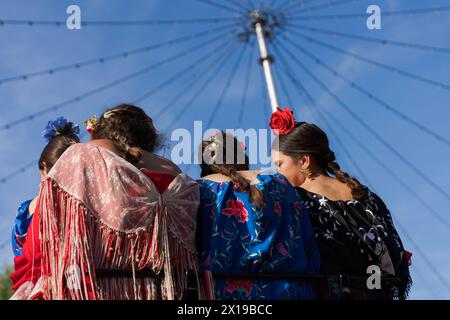 Les jeunes femmes portant des robes de flamenco traditionnelles, souvent de couleurs vives, et accessoirisées avec des fleurs dans leurs cheveux sont vues pendant la foire. La Foire d'avril est l'un des festivals les plus internationaux et les plus populaires de Séville. Créé en 1847 comme une foire à l’élevage, au fil du temps l’aspect festif de l’événement a fini par reprendre la partie commerciale, jusqu’à ce qu’il devienne un événement incontournable pour les Sévilliens. Pendant une semaine, plus d’un millier de stands installés dans le parc des expositions sont devenus la deuxième maison des habitants de cette ville, un espace où ils peuvent partager et s’amuser en compagnie jusqu’aux premières heures de la journée Banque D'Images