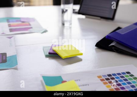 Des notes adhésives colorées et des papiers de conception d'application sont couchés sur une table dans un bureau d'affaires moderne Banque D'Images