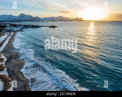 Vue aérienne de la plage et de la mer en face des montagnes au coucher du soleil, hiver, Skaland, Senja, Troms, Norvège, Europe Banque D'Images