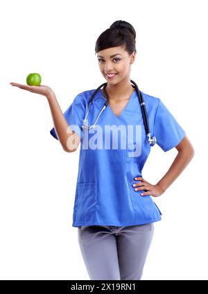 Infirmière, femme et pomme à portée de main dans le studio pour les soins de santé et la nourriture saine pour le choix naturel. Travailleur médical ou médecin en portrait avec des fruits dans la paume Banque D'Images