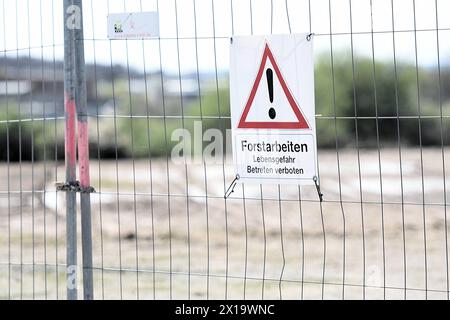 An einem Absperrzaun an einem Industriegebiet nahe des Flughafens Zweibrücken hängt ein rot-Weißes Schild, auf dem vor Forstarbeiten und möglicher Lebensgefahr gewarnt wird. Warnschild Forstarbeiten *** Un panneau rouge et blanc est accroché à une clôture de barrière dans une zone industrielle près de l'aéroport de Zweibrücken avertissant des travaux forestiers et un panneau d'avertissement de danger possible pour la vie pour les travaux forestiers Banque D'Images