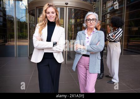 Deux femmes d'affaires caucasiennes souriantes posant pour la caméra. Banque D'Images