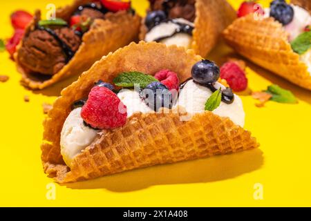 Diverses crèmes glacées au taco sucré. Coquilles de tacos à gaufrer avec glace au chocolat et à la vanille avec différents fruits, baies, garnitures Banque D'Images