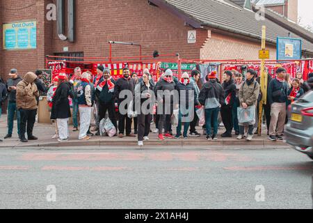 Les fans de football de Liverpool attendent à l'arrêt de bus sur Anfield Road après le match. Banque D'Images