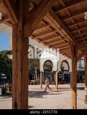 Place du marché de Bermondsey, vue sur l'espace public avec tour de l'horloge argentée, surplomb de la zone couverte au premier plan, détail de construction en bois. Le bleu, Banque D'Images