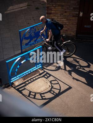 Bermondsey Market place, « The Blue » wayfinging / bornes jetant une ombre avec le cycliste. The Blue, Londres, Royaume-Uni. Architecte : assembler Banque D'Images