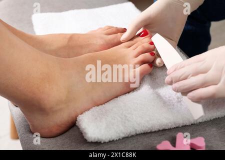 Pédicuriste classant les ongles des orteils du client dans un salon de beauté, gros plan Banque D'Images