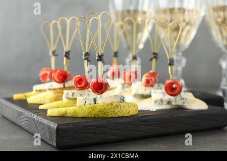 Canapés savoureux avec poires, fromage bleu et prosciutto sur table grise, gros plan Banque D'Images