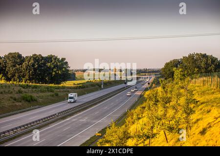 Coucher de soleil sur une autoroute tranquille en République tchèque, avec des véhicules en mouvement. Banque D'Images