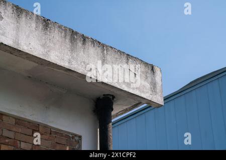 façade avec corniche de bâtiment avec infiltration et érosion du plâtre due au temps et mortier désintégrant. les problèmes d'infiltration et de degr Banque D'Images