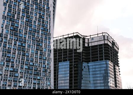 Low angle view of modern immeuble de bureaux en chantier contre ciel en ville Banque D'Images