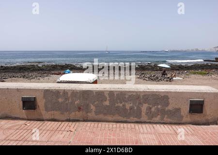 Palm-Mar, Tenerife, 16 avril 2024 - Graffiti qui a dit une fois 'salaire moyen dans les îles Canaries 1,200E' a été peint à Palm-Mar, Tenerife par des fonctionnaires. - Graffiti anti-touristique griffonné sur les murs dans la station balnéaire de Palm-Mar dans le sud de l'île de Tenerife a été peint par des fonctionnaires qui essaient de transmettre la petite ville comme «touristique convivial» plusieurs messages ont été pulvérisés il ya des semaines sur les murs et les bancs, cependant, une nouvelle peinture blanche couvre désormais les zones touchées et un slogan qui écrivait « salaire moyen aux îles Canaries 1 200E » est désormais recouvert de peinture grise. Credi Banque D'Images