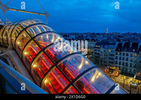 Escalator dans le Centre Pompidou (ou Beaubourg), vue sur les toits de Paris et la tour Eiffel la nuit Banque D'Images