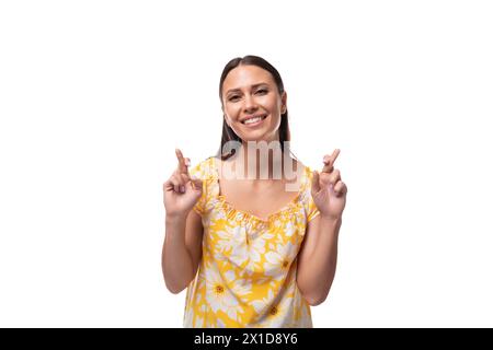 femme brune confiante européenne avec les cheveux lâches portant un t-shirt jaune sur un fond blanc avec espace copie Banque D'Images