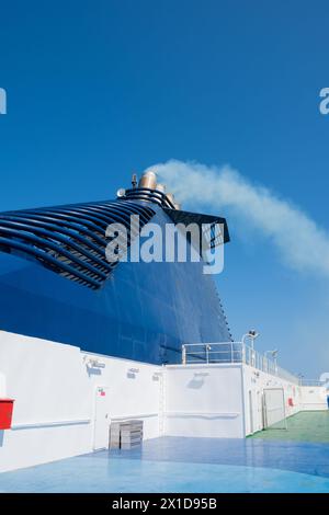 Ferry dans la mer et fumée de la cheminée contre le ciel bleu. Concept de transport et de voyage Banque D'Images