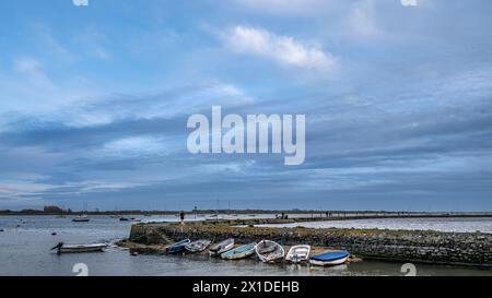 Bateaux à rames amarrés le long du mur du port et de la jetée d'une station de pêche et de plaisance anglaise. Banque D'Images